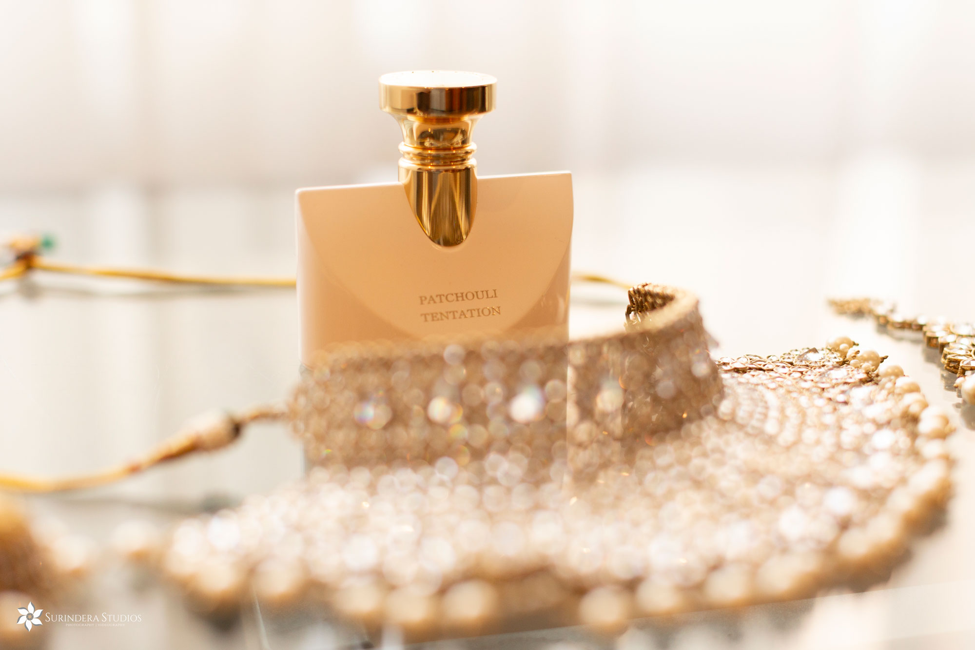 Bride's Indian wedding jewellery (gold necklace) and bottle of perfume